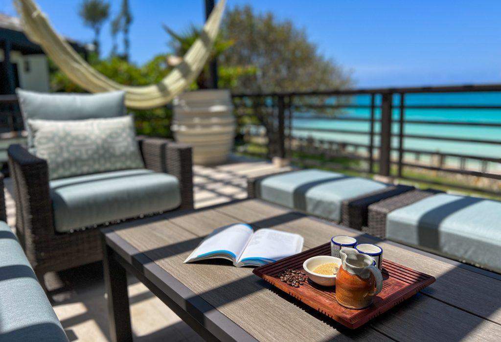 Morning coffee and open book on the upstairs balcony at Sea Salt Villa in Ocho Rios Jamaica overlooking the quiet gated beachfront and turquoise Caribbean Sea.