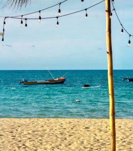 Small fishing boat on turquoise water off the beach at Sharkies Seafood Restaurant in Runaway Bay, Jamaica.