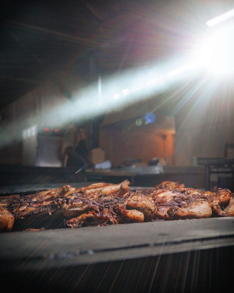 Boston-style jerk chicken grilling at Ultimate Jerk Centre in Discovery Bay, Jamaica.
