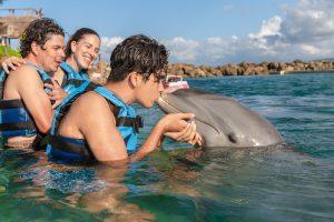 Guest kissing dolphin during Dolphin Cove experience in Ocho Rios, Jamaica.