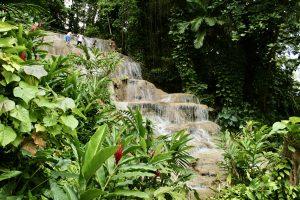 Visitors climbing waterfall at Konoko Falls in Ocho Rios Jamaica.