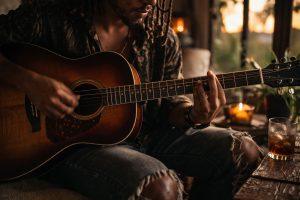 Guitarist playing live music at a private villa in Jamaica during a relaxed evening setting.