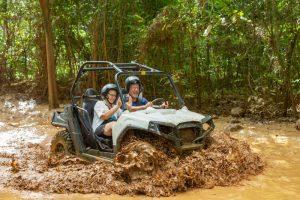 Guests driving buggy through muddy trail at Yaaman Adventure Park near Ocho Rios, Jamaica.