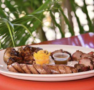 Jerk pork, jerk sausage, and jerk chicken platter at Ocho Rios Jerk Centre in Jamaica.