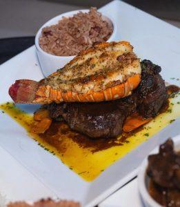 Grilled lobster tail and steak served with rice and peas at Plantation Smokehouse in Ocho Rios, Jamaica.